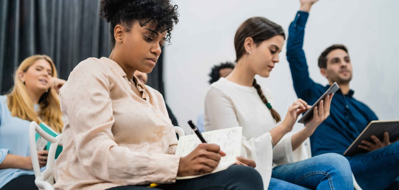 group-young-people-sitting-conference-together-while-raising-their-hands-ask-question-business-team-meeting-seminar-training-concept (1)